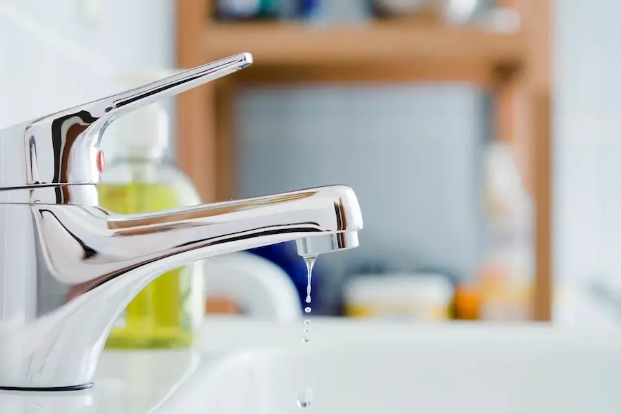 Plumber repairing dripping faucet in Fresno, CA